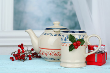 Christmas composition with cup and teapot of hot drink,