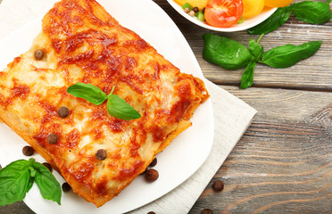 Portion of tasty lasagna on wooden table