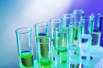 Green fluid in test-tubes on the light background