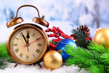 Fototapeta na wymiar Alarm clock with Christmas decorations on light background