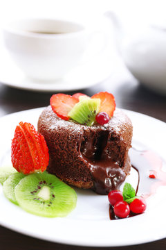 Hot chocolate pudding with fondant centre with fruits, close-up