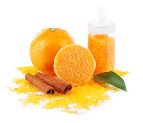 Bottle of bath salt with fresh orange, bar of soap and cinnamon
