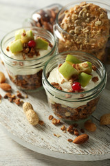 Healthy layered dessert with muesli and fruits on table