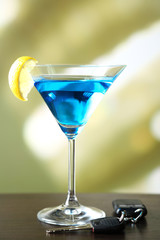 Glass of alcoholic drink and car key,