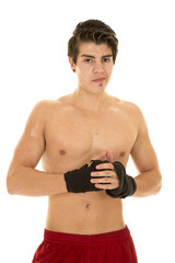 man no shirt red shorts hands together wrapped for fighting