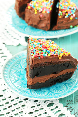Chocolate cake with colorful sweet powder on table close-up