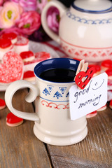 Cup of tea with card that says good morning on table close-up