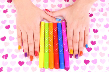 Multicolor female manicure with markers on bright background