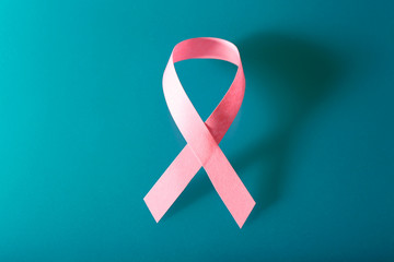 Pink breast cancer ribbon on blue background