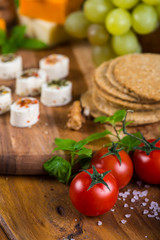 tomatoes with cheese snacks on wooden board