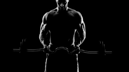 Fototapeta na wymiar Close up of young muscular man lifting weights over dark backgro