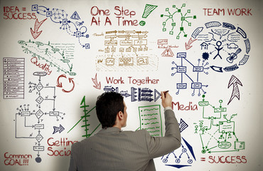 Businessman writing on the wall