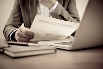 Businessman analyzing investment charts with laptop. Accounting