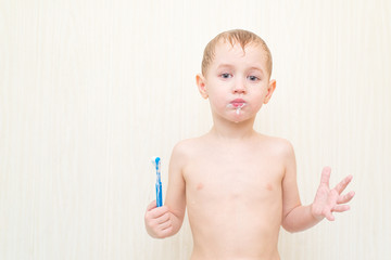 Little boy brushing his teeth blue brush in the bath