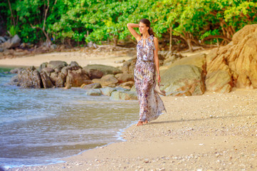 Fototapeta na wymiar Beautiful young girl posing on a sandy beach