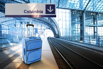 Departure for Columbia. Blue suitcase at the railway station