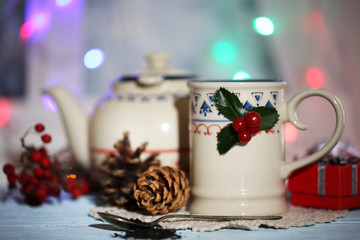 Christmas composition with cup and teapot of hot drink,