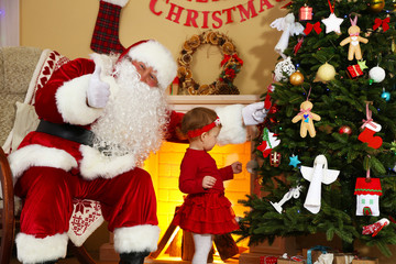 Santa Claus giving  present to  little cute girl near