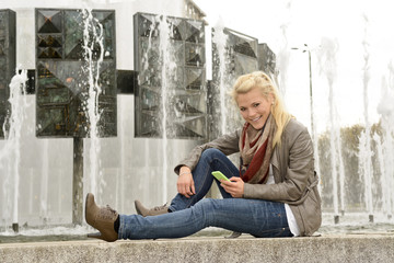 Junge Frau mit Smartphone, Strausberger Platz, Berlin