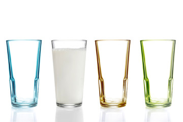 Drei leere bunte Trinkgläser und ein gefülltes Glas