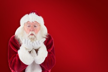 Composite image of santa claus blows something away