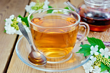 Tea from flowers of viburnum on wooden board