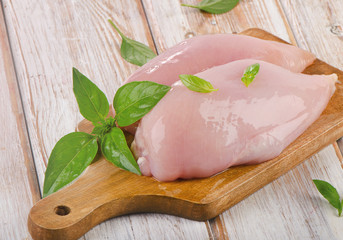 Raw chicken breast fillets on a cutting board.