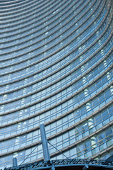 Glass Facade of company building with reflection of blue sky.