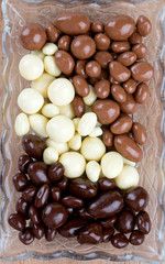 chocolate covered nuts and raisins on wooden surface
