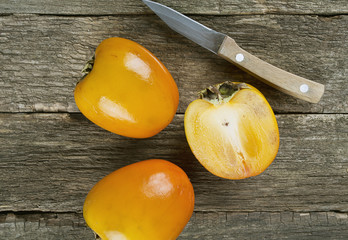 persimmons on wooden surface