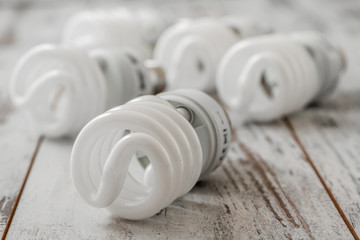 Energie Saver Fluorescent Light Bulbs on White Wooden Background