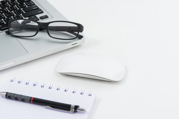 Blank business laptop, mouse, pen, glasses and note