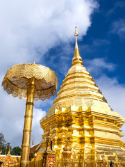 Golden pagoda of Wat Phra That Doi Suthep under cloudy blue sky