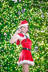 Pretty Asian girl in Santa costume for Christmas with night ligh