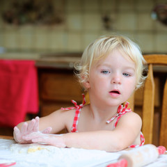Fototapeta premium Little girl making cookies in the kitchen