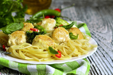 Spaghetti with chicken meatballs and broccoli.