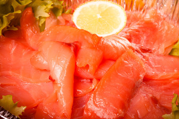 sliced salmon laid in a bowl with lemon. tinted