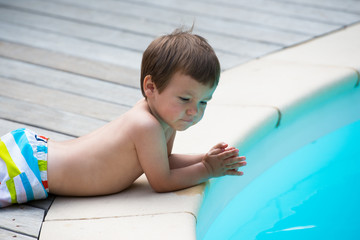 enfant seul au bord d'une piscine