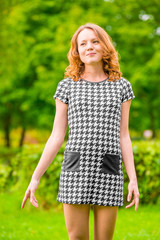 Fototapeta premium happy girl in a dress on a background of green park