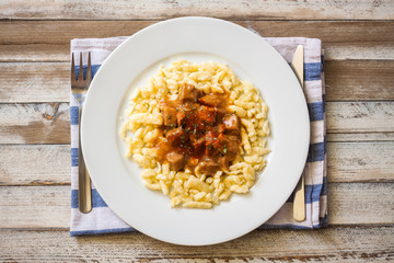 Hungarian goulash of veal with dumplings, on wooden table