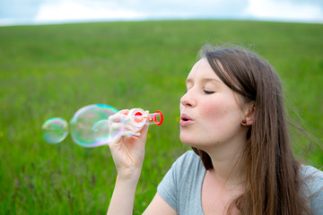 young woman blowing bubbles