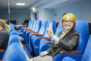 Naklejka premium in the conference hall sits a smiling woman
