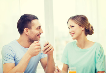 smiling couple having breakfast at home