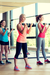 group of women with dumbbells in gym
