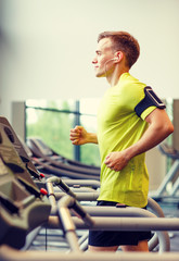 smiling man exercising on treadmill in gym