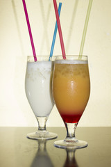 A Pair Of Glasses Filled With Delicious Cocktails