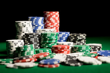 close up of casino chips on green table surface