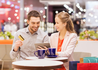 couple with tablet pc and credit card in mall