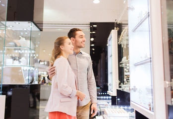 couple looking to shopping window at jewelry store