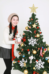 크리스마스 트리 옆의 젊은 한국 여성